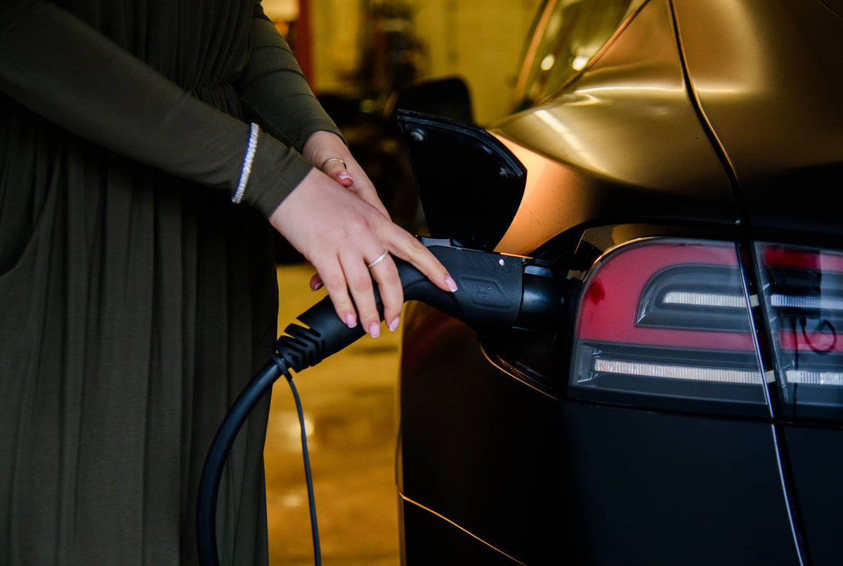 Person plugging an electric car with a charging cable - Dashsharing